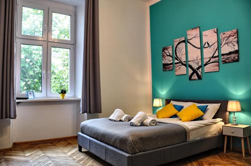a bedroom with a bed with a green wall at Wiślna 4 by Homeprime in Krakow