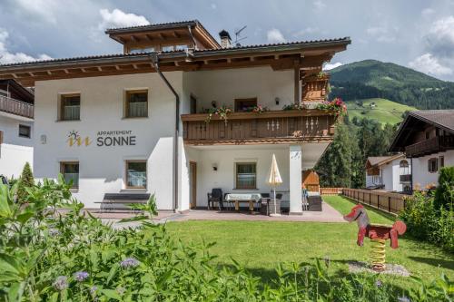 a large house with a balcony and a yard at App Sonne Nr 17 in Lutago