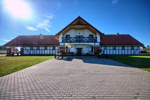 a large white building with a brown roof at Storczykowe Wzgórze in Paszowice