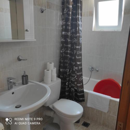 a bathroom with a toilet and a sink and a shower curtain at ARETI 3 in Petalidi