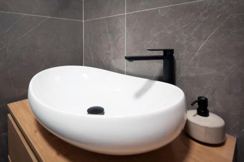 lavabo blanco con grifo negro en el baño en Jazz Rooms and Apartments, en Rovinj