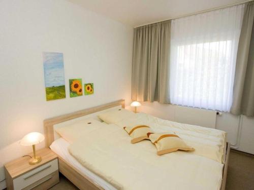 a bedroom with a large white bed with a window at Ferienhaus große Krabbe in Neuharlingersiel