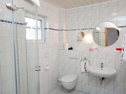 a white bathroom with a toilet and a sink at Ferienhaus große Krabbe in Neuharlingersiel