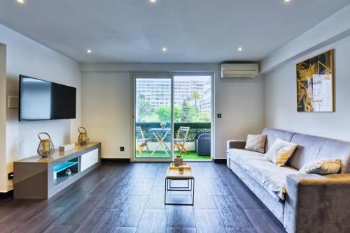 salon z kanapą i telewizorem w obiekcie LE VENITIA studio raffiné avec balcon mignon, pour votre séjour à deux w Cannes