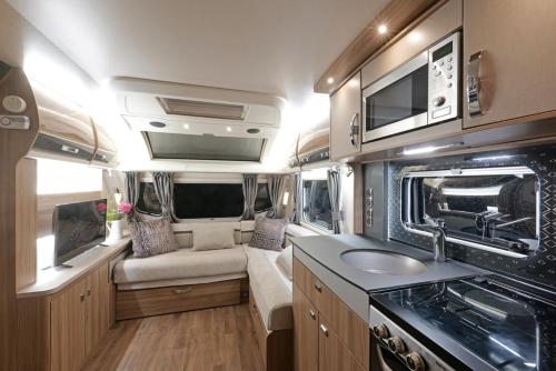 an rv with a kitchen and a sink in it at Pinetum Garden Retreats in St Austell