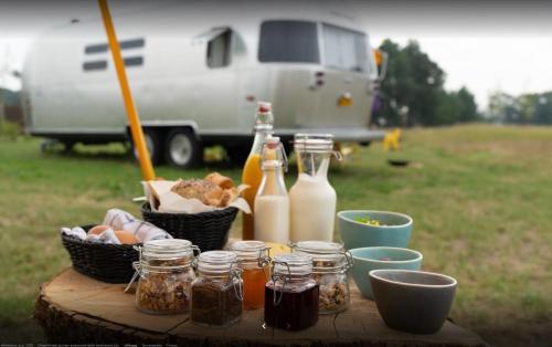 una mesa de picnic con tarros de comida y botellas de leche en Amerikaanse Airstream voor 2 personen, en Reutum