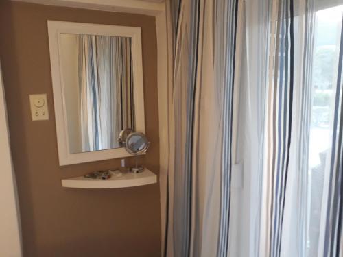 a bathroom with a mirror and a window at Budva center apartmant in Budva