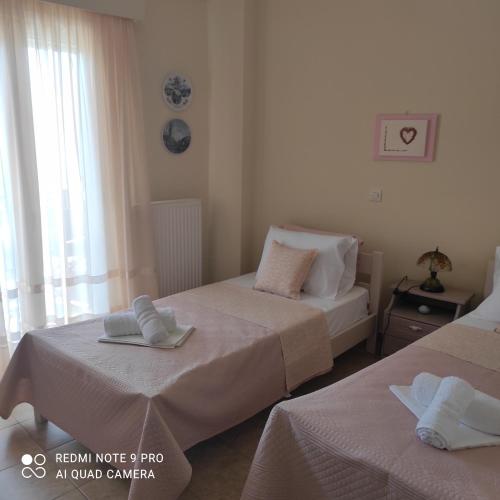 a bedroom with two beds with towels on them at ARETI 3 in Petalidi
