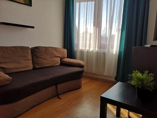 a living room with a couch and a window at Parton Hotel & Bowling in Tiszakécske