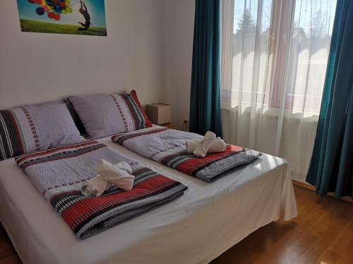 a bed with towels on it with a window at Parton Hotel & Bowling in Tiszakécske