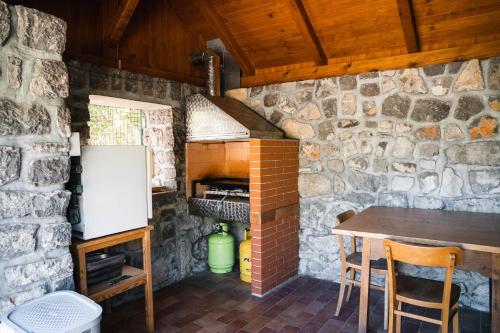 a kitchen with a table and a brick wall at Country House Sveta Ana in Stari Trg pri Ložu
