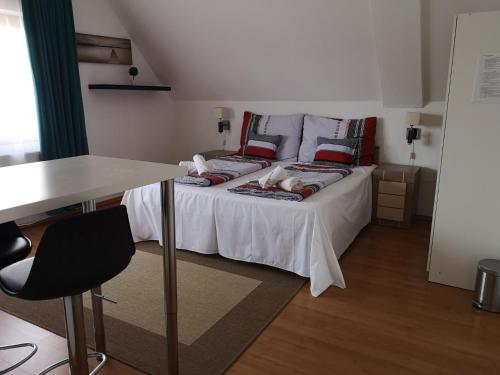 a bedroom with a bed with a table and a desk at Parton Hotel & Bowling in Tiszakécske