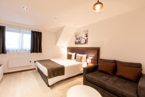 a hotel room with a bed and a couch at Apart & Spa Zoned in Kopaonik