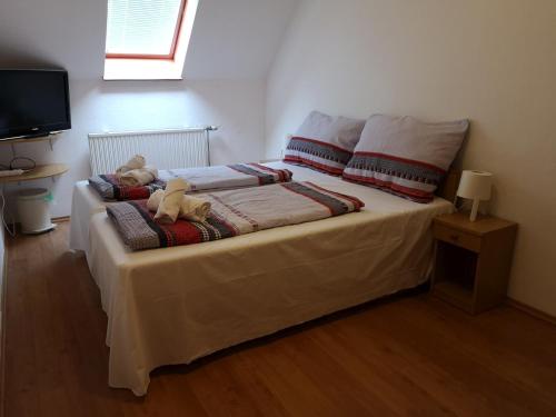 a bed with a teddy bear sitting on top of it at Parton Hotel & Bowling in Tiszakécske