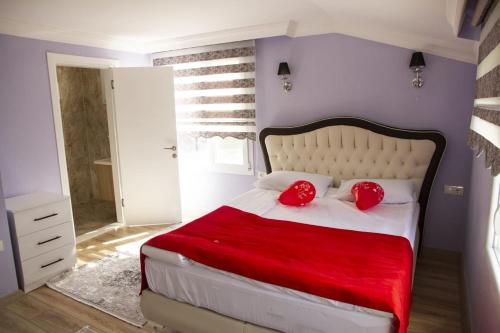 a bedroom with a large bed with red pillows at Kartal Gözü Konaklama tesisi in Rize