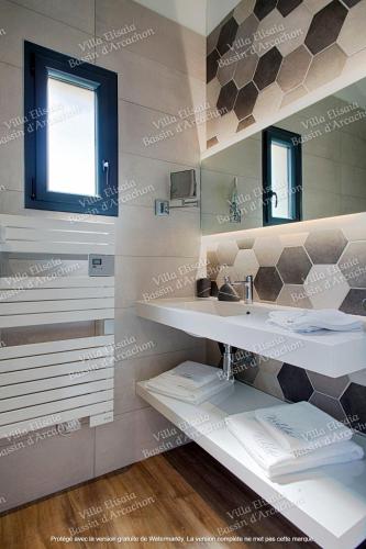 une salle de bain avec deux lavabos et un miroir dans l'établissement Gite Villa Elisaia location de meublés de tourisme chez l'habitant, à Arès