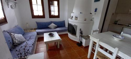a living room with a blue couch and a table at Villa Katerina in Platanias