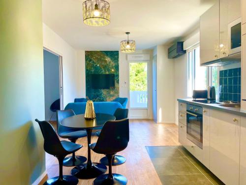 a kitchen and living room with a table and chairs at Villa Elisa M in Aubenas