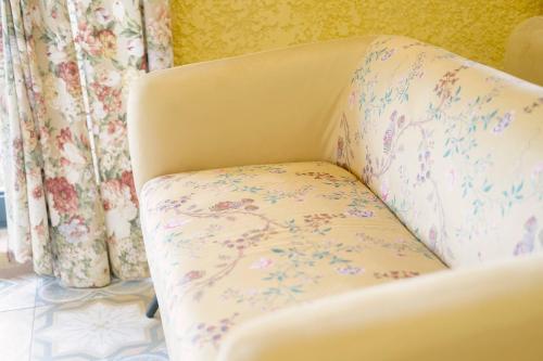 a white chair with flowers on it in a room at Hotel Cerro La Nina in Beceña