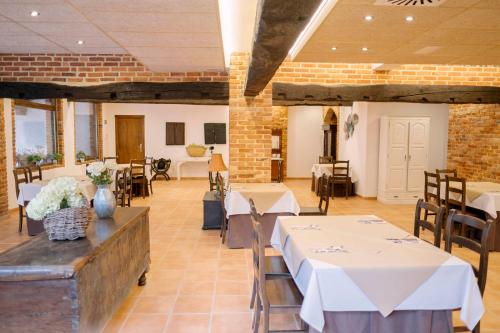 a restaurant with tables and chairs and a brick wall at Hotel Cerro La Nina in Beceña