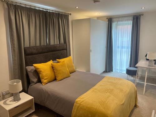 1 dormitorio con 1 cama grande con almohadas amarillas en Lovely 2 Bed apartment in Leeds centre (Netflix), en Leeds