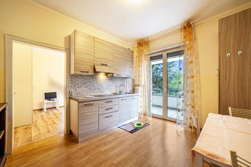 a kitchen with wooden cabinets and a large window at Residence Hubertus Apartment 4 in Merano