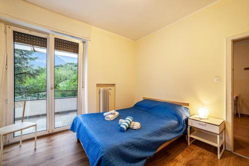 a bedroom with a blue bed and a large window at Residence Hubertus Apartment 4 in Merano