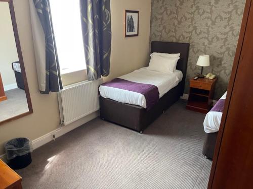 a small bedroom with a bed and a window at Manor Hotel by Greene King Inns in Yeovil