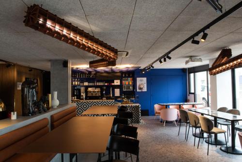 a restaurant with blue walls and tables and chairs at Tribe Carcassonne in Carcassonne