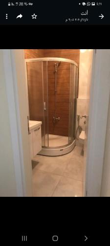 uma casa de banho com um chuveiro e uma porta de vidro em شقة بمنتجع مياتيرمال em Kaplıca