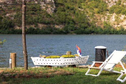 a white boat sitting on the grass near a lake at Apartman Barka in Golubac