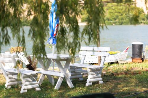 a picnic table and chairs in front of a lake at Apartman Barka in Golubac