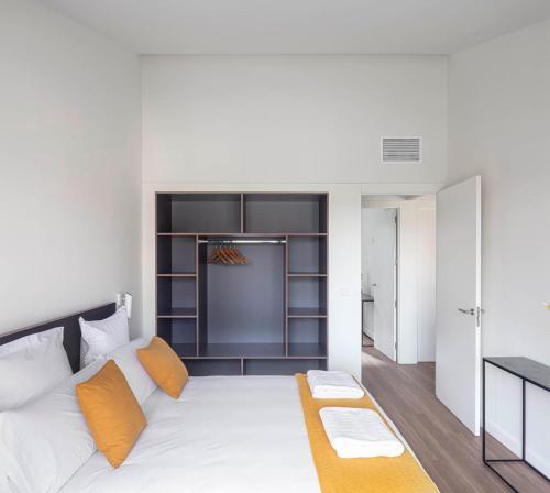 a bedroom with a large white bed with orange pillows at Invino Apartments in Logroño