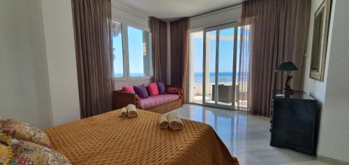 ein Schlafzimmer mit einem Bett, einem Sofa und Fenstern in der Unterkunft Al lado del mar "Villa Tortuga 12" in Lloret de Mar