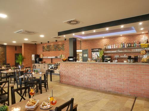 a restaurant with tables and chairs and a brick wall at COMFORT Rožnov in Rožnov pod Radhoštěm