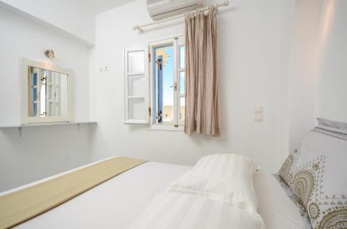 a white room with a bed and a window at Diamantis Kitesurf Villa in Mikri Vigla