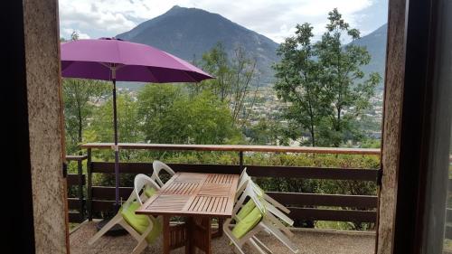 a table and chairs with an umbrella on a balcony at Studio sympa avec terrasse , maxi 4 pers.Briançon in Briançon