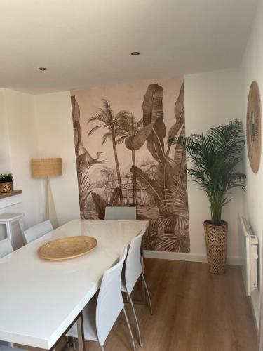 a dining room with a table and a painting on the wall at Le Clos des Glycines in Saint-Martin-lez-Tatinghem