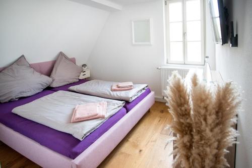 a bed with pink and white pillows in a room at Anni`s Inn in Bruchsal