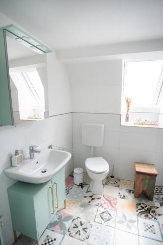 a bathroom with a sink and a toilet and a mirror at Anni`s Inn in Bruchsal