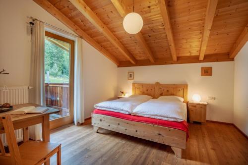 ein Schlafzimmer mit einem Bett und einem großen Fenster in der Unterkunft Apartment Mitterdorfer in Abfaltersbach