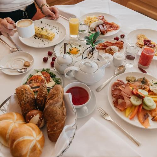 ザールバッハ・ヒンターグレムにあるHotel Alpine Palaceの朝食の食べ物が載ったテーブル