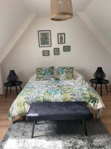 - une chambre avec un lit et un banc dans l'établissement Le Clos des Glycines, à Saint-Martin-lez-Tatinghem