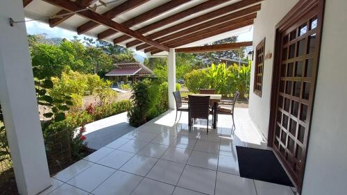 a patio with a table and chairs in a house at Casa Hibiscus in Ojochal