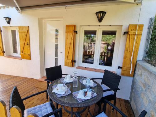 un tavolo da pranzo e sedie su una veranda con tavolo e sedie. di La petite Luciole entre mer et montagne. a Cagnes-sur-Mer