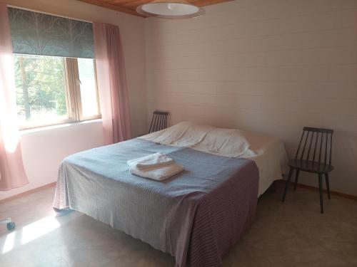 Un dormitorio con una cama con dos sillas y una ventana. en Villa Aleksi with Sauna, en Rovaniemi