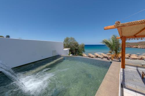 a swimming pool with a waterfall in a villa at Calma Boutique Hotel in Posidhonía