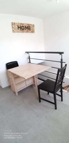 una mesa de madera y una silla junto a un banco en Appartement une chambre proche PARIS, en Argenteuil