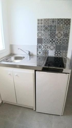 une cuisine avec un évier et un plan de travail dans l'établissement Appartement une chambre proche PARIS, à Argenteuil