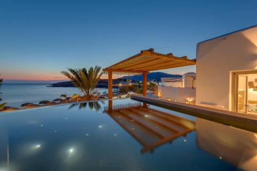a villa with a swimming pool at night at Calma Boutique Hotel in Posidhon&iacute;a